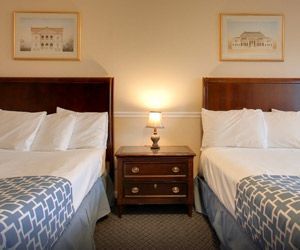 A hotel room with two beds and a nightstand.