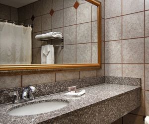 A bathroom with a sink and a large mirror.