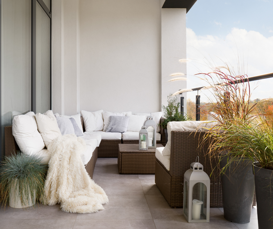 A balcony with wicker furniture and potted plants.
