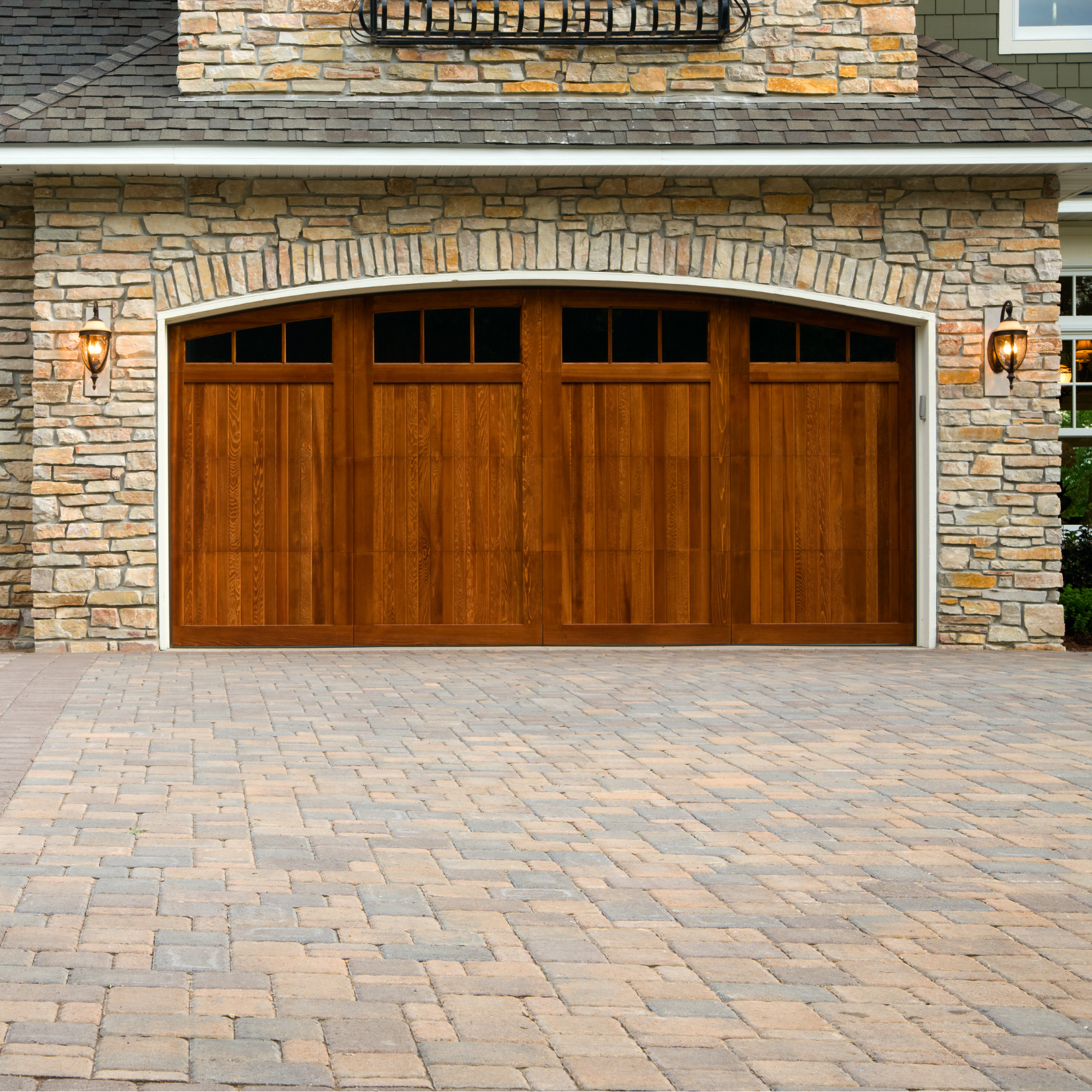A wooden garage door in front of a stone building