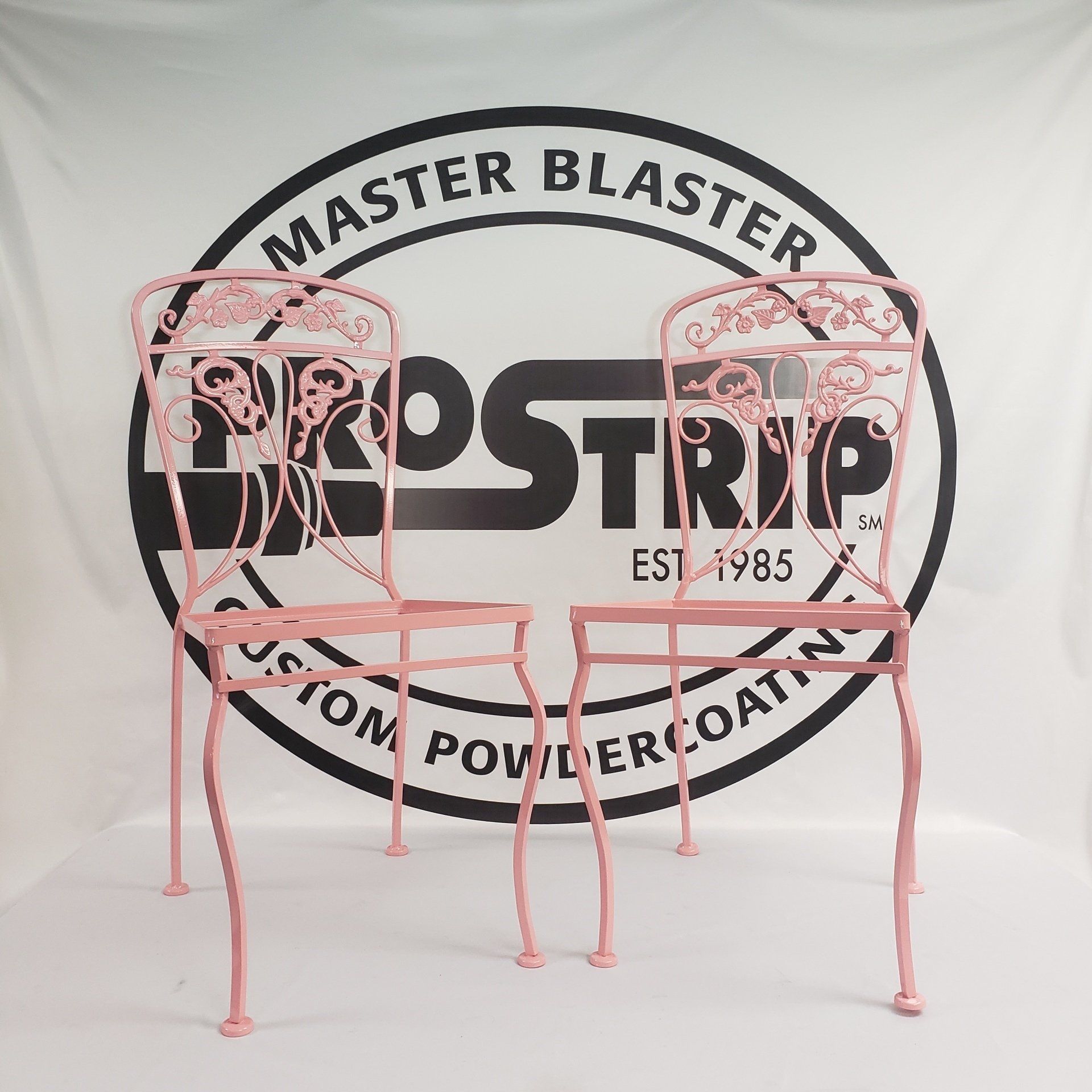 Two pink chairs are sitting in front of a master blaster logo