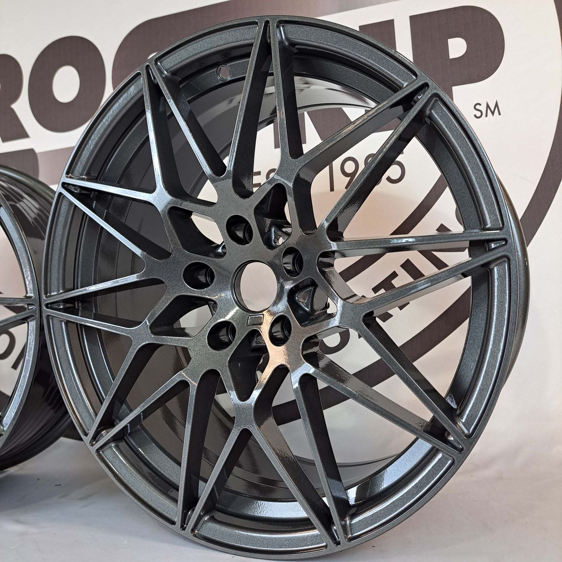 A close up of a wheel with a logo in the background