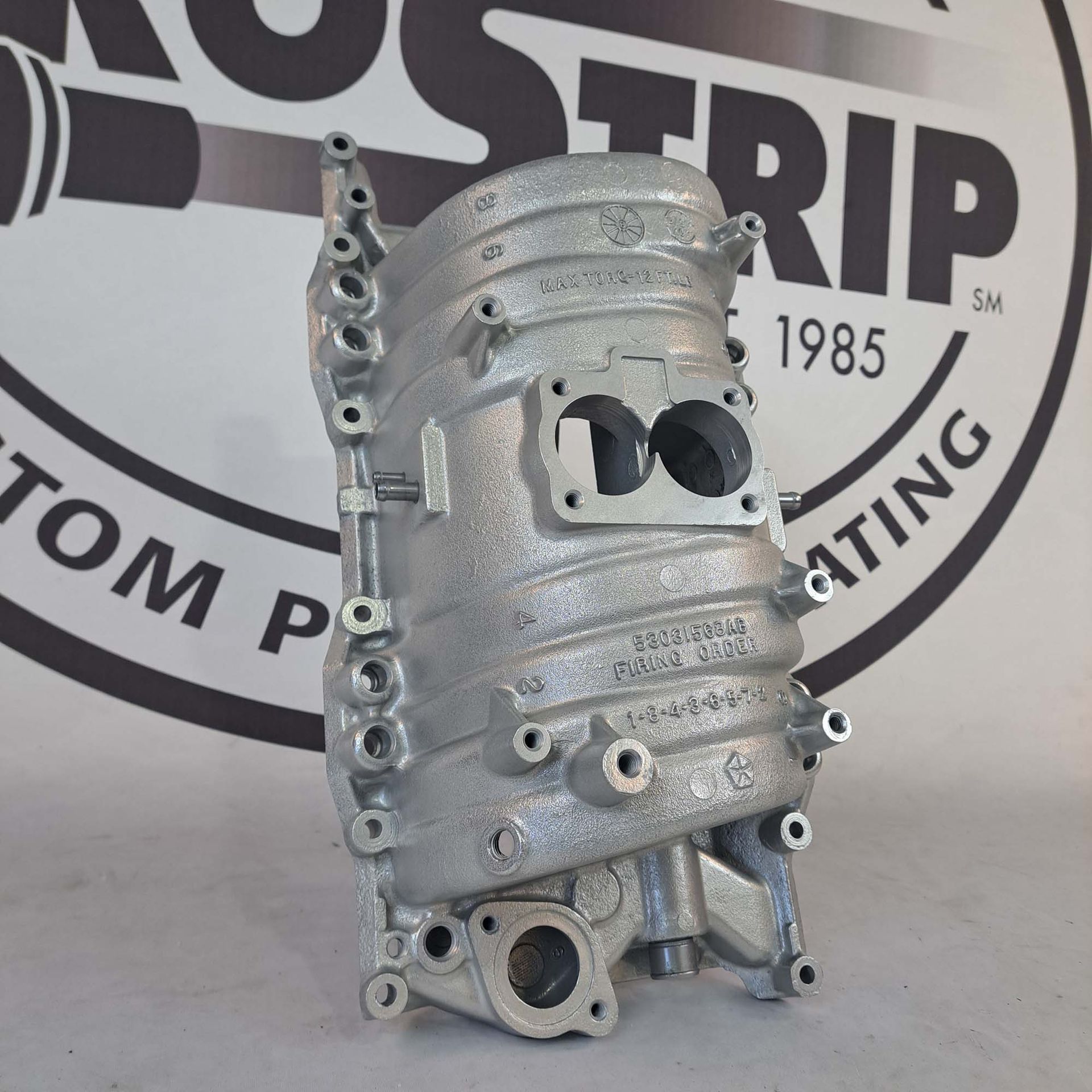 A piece of metal sits in front of a 1985 logo