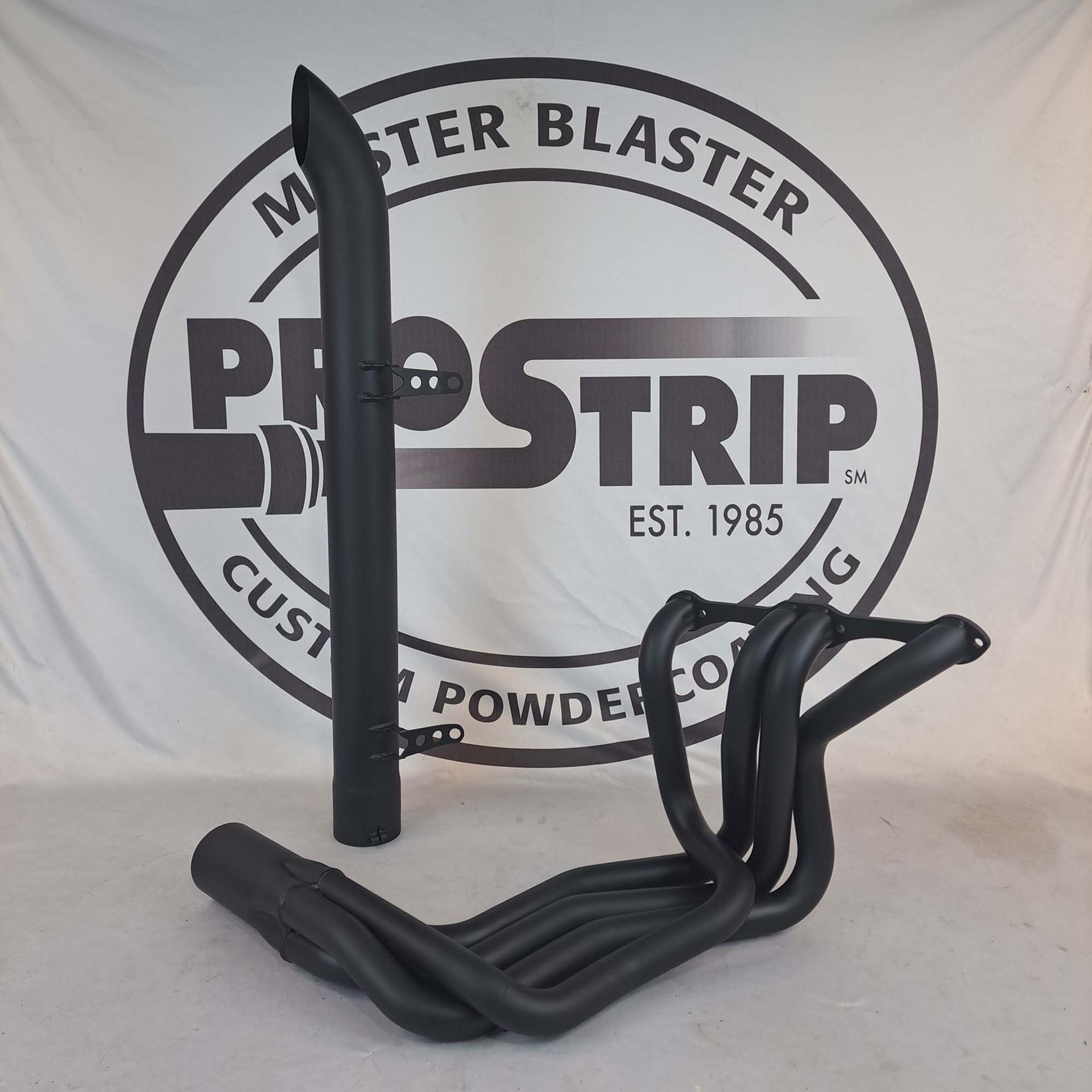 A black pipe in front of a master blaster logo