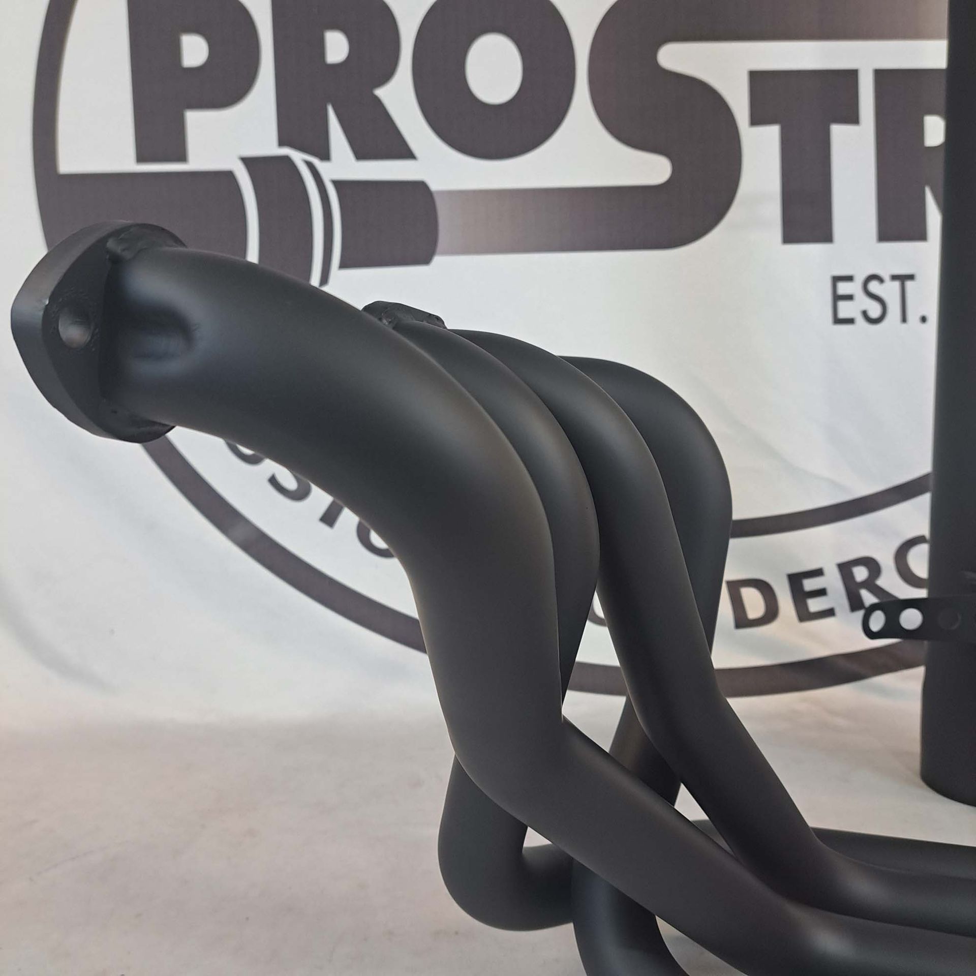 A close up of a exhaust pipe in front of a prostr logo