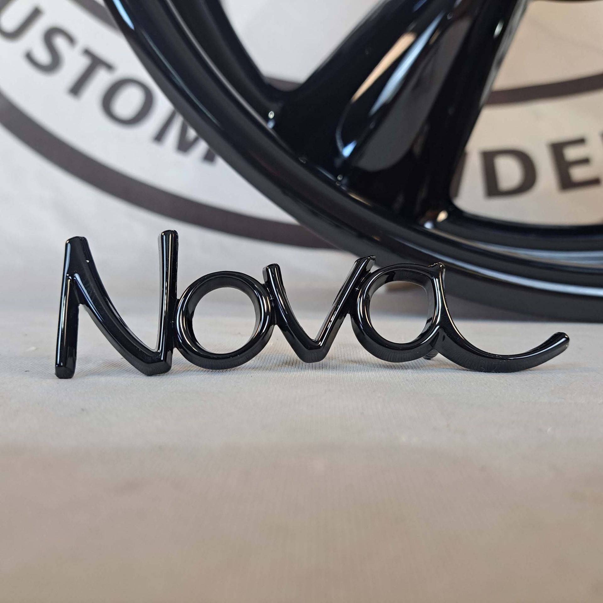 A black nova emblem sits next to a black wheel