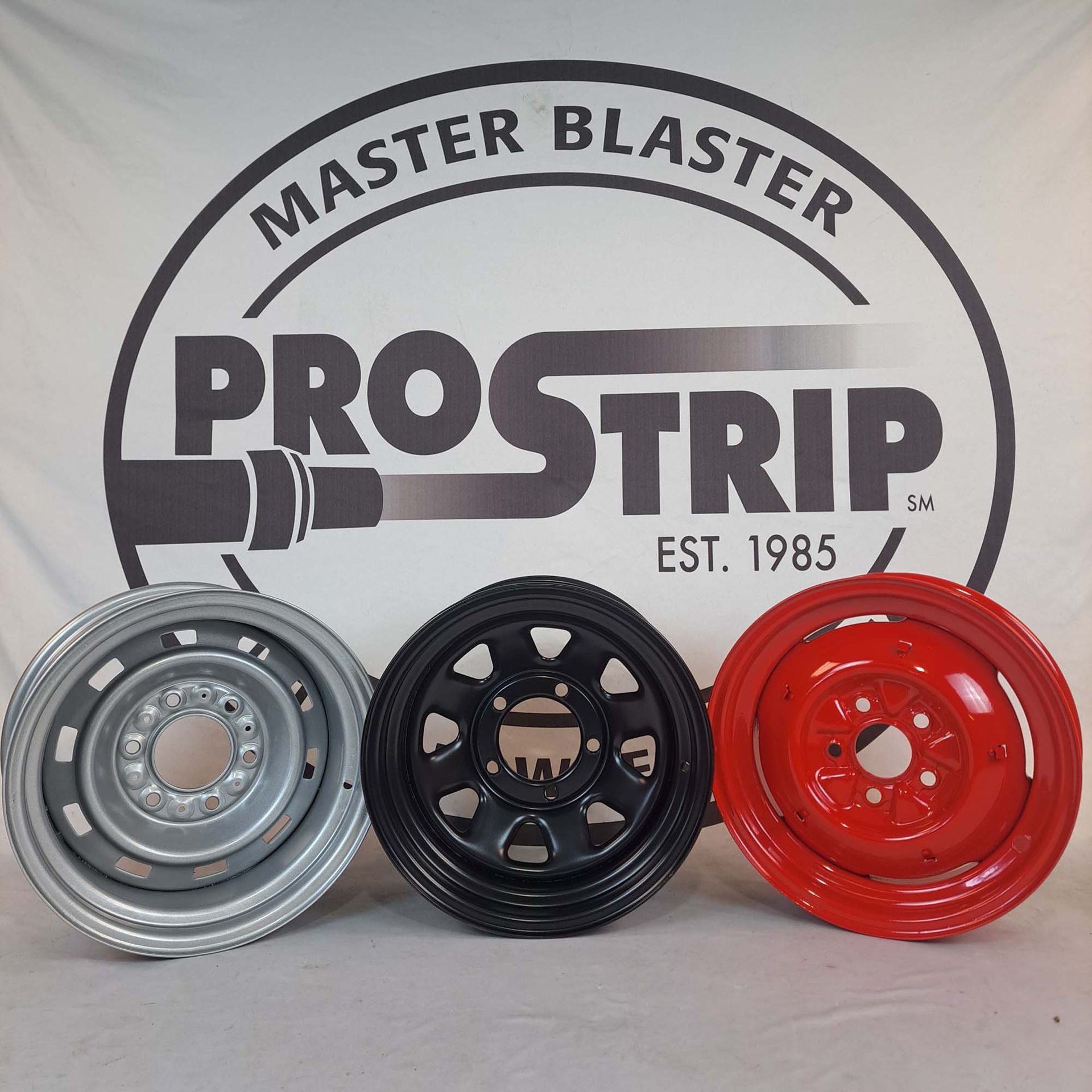 Three wheels are lined up in front of a master blaster logo