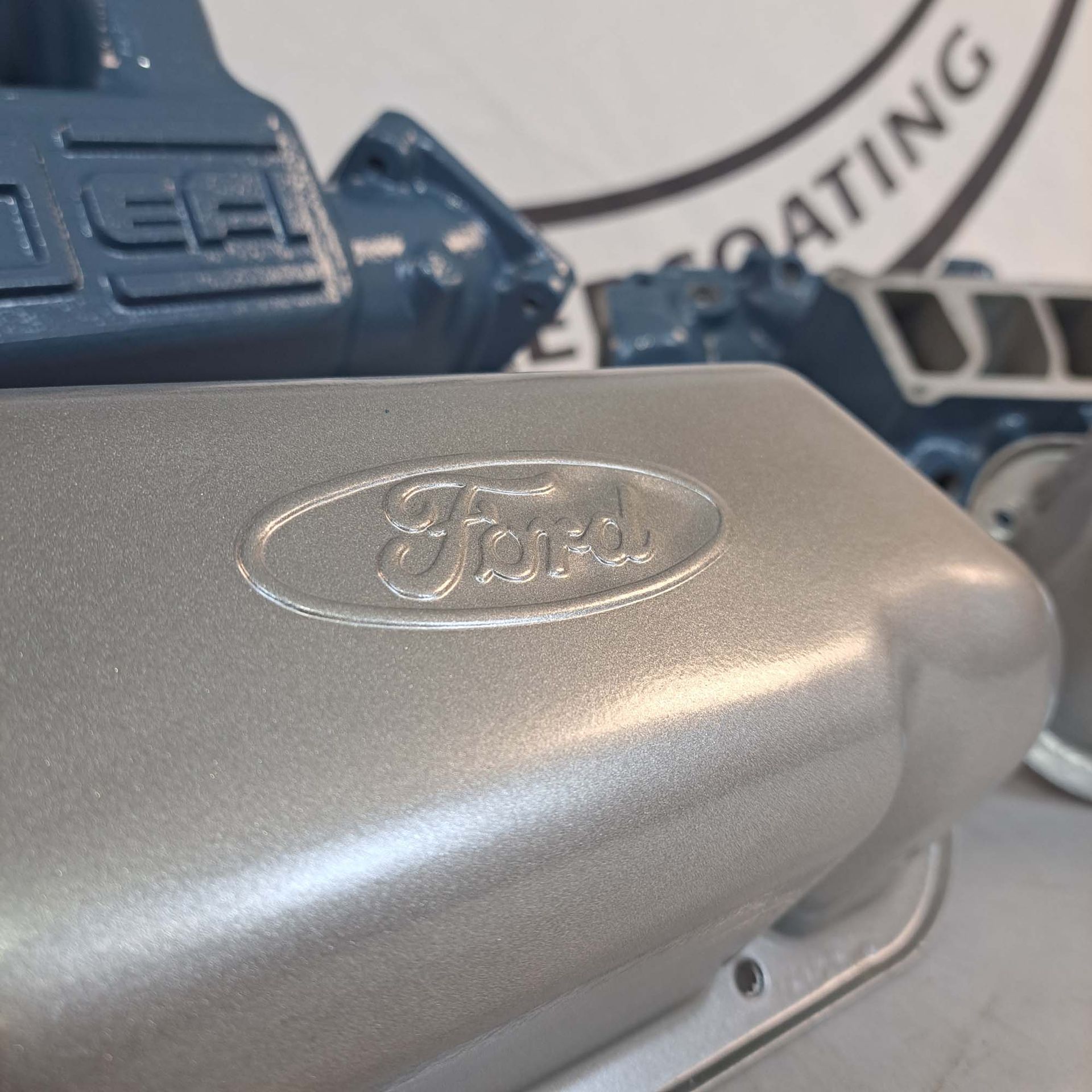 A close up of a ford engine cover on a table