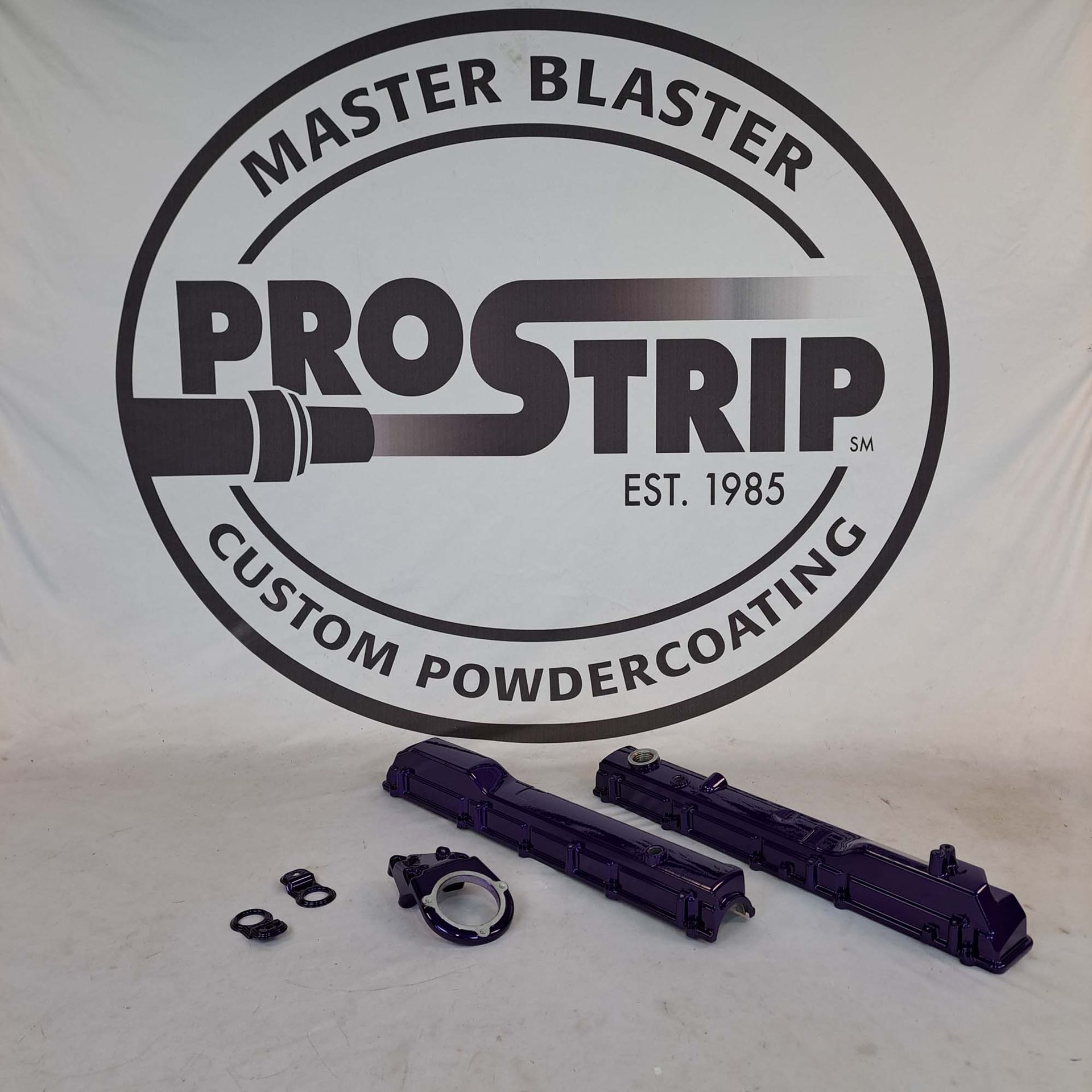 A black and white logo for master blaster prostrip custom powdercoating