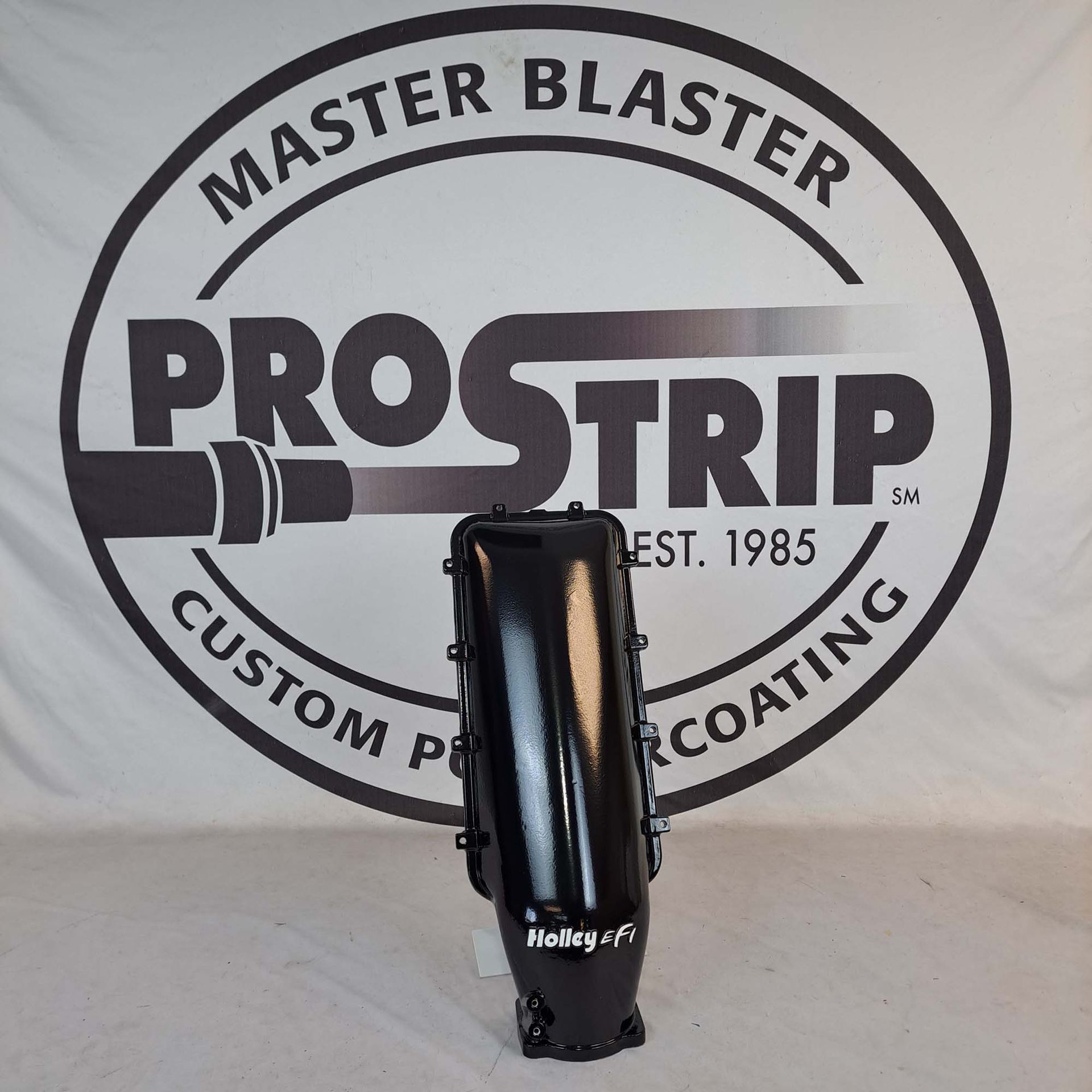 A black object is sitting in front of a master blaster logo