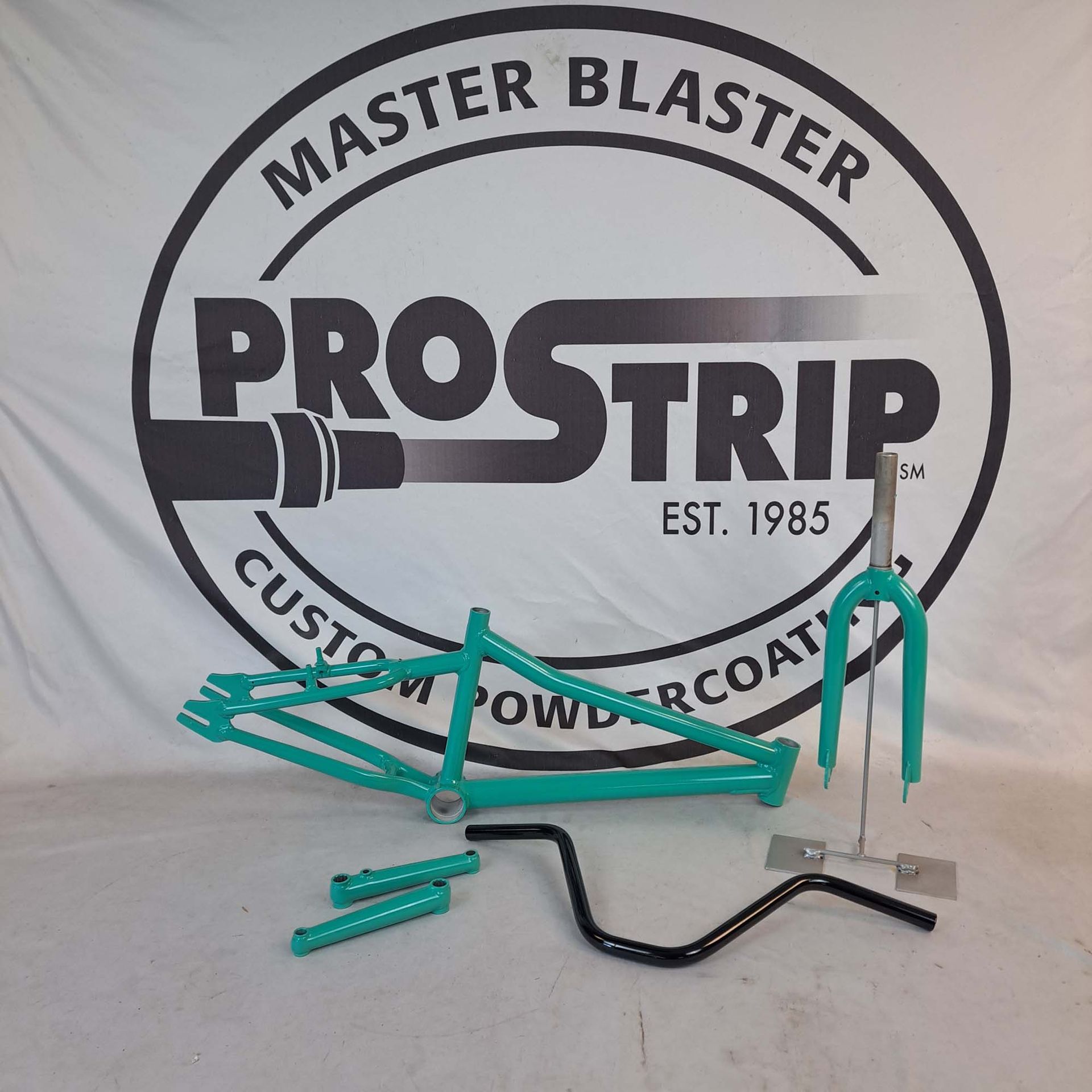 A master blaster logo with a bicycle frame in front of it