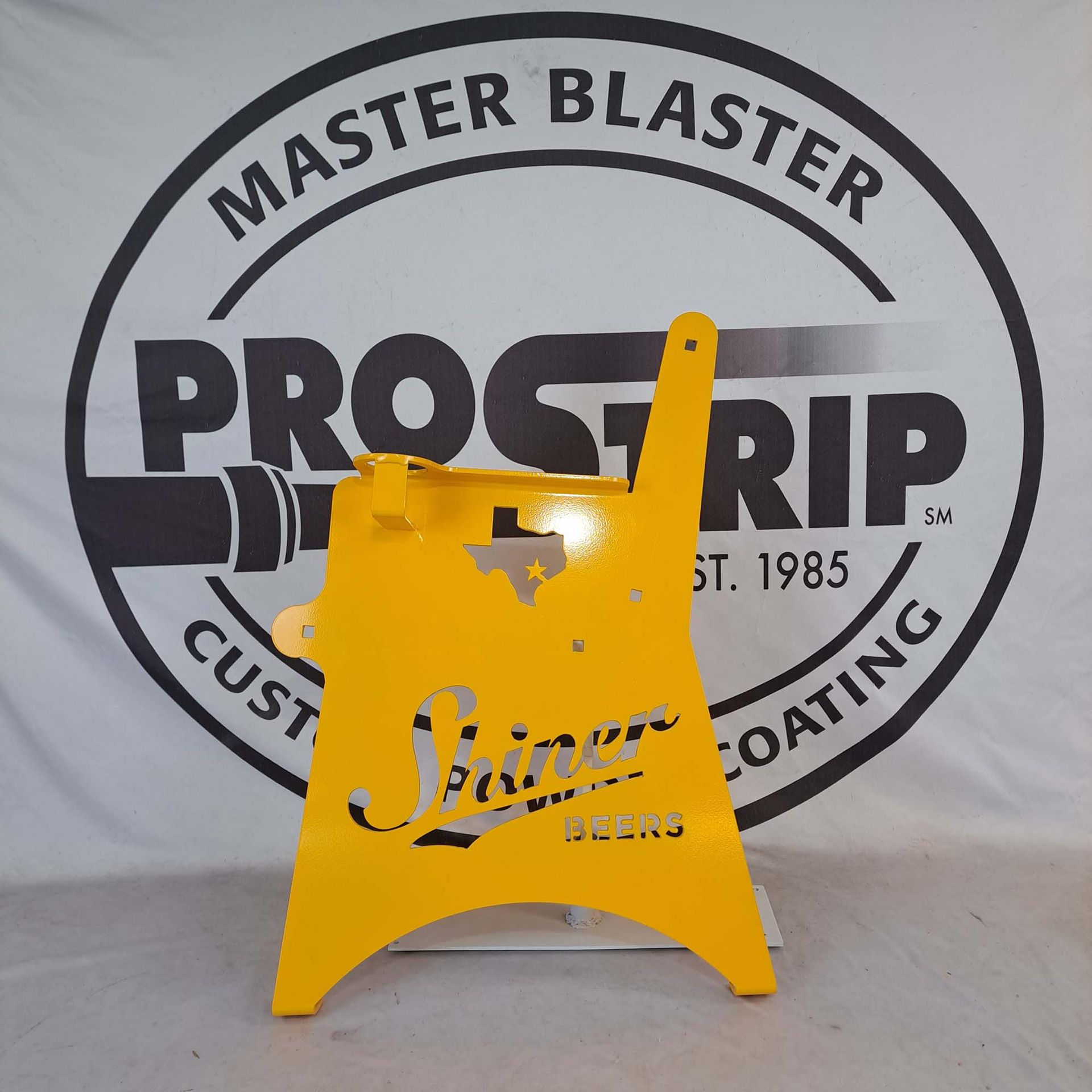 A yellow sign is in front of a master blaster logo