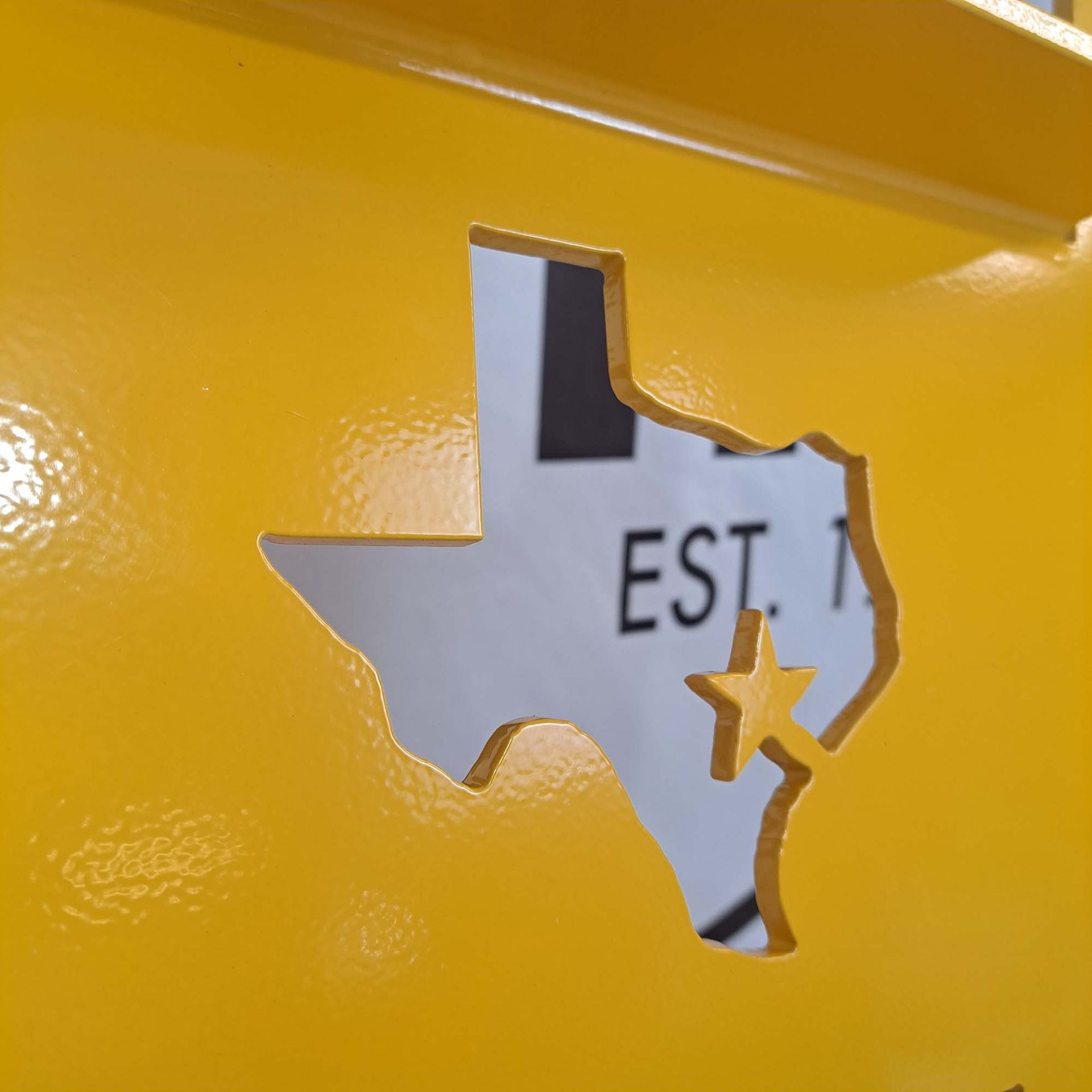 A yellow wall with the state of texas cut out of it