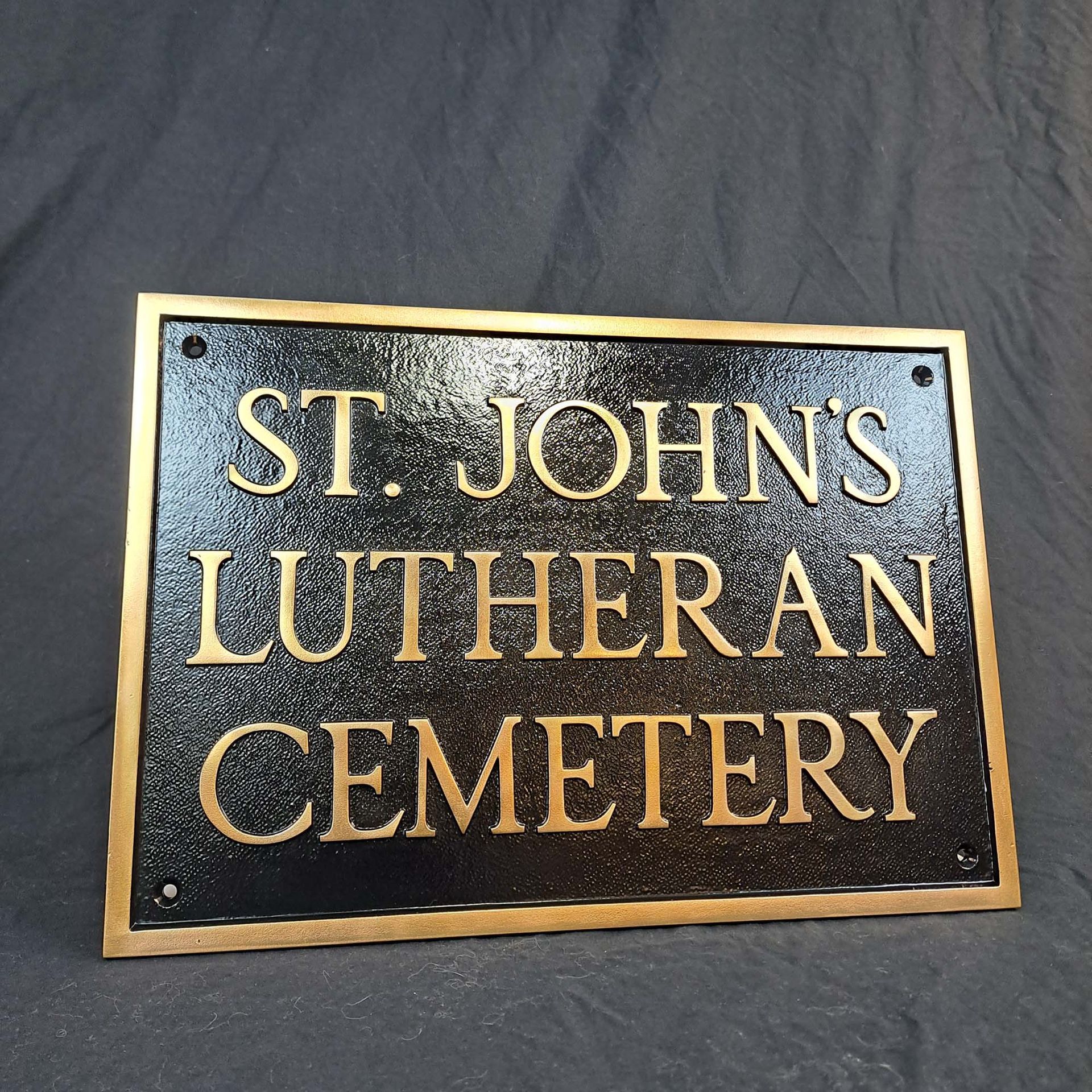 A black and gold sign for st. john 's lutheran cemetery