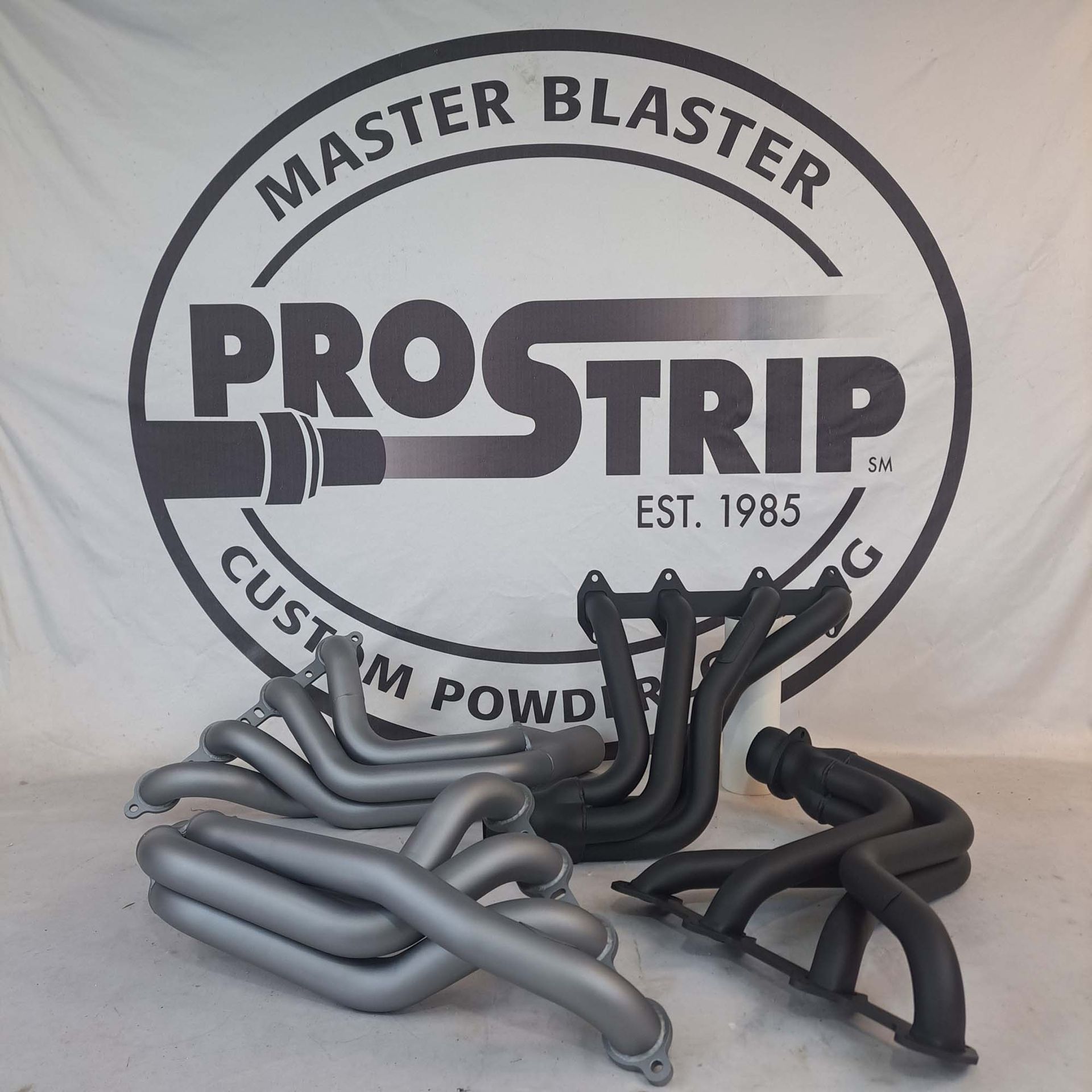 Exhaust pipes are sitting in front of a master blaster logo