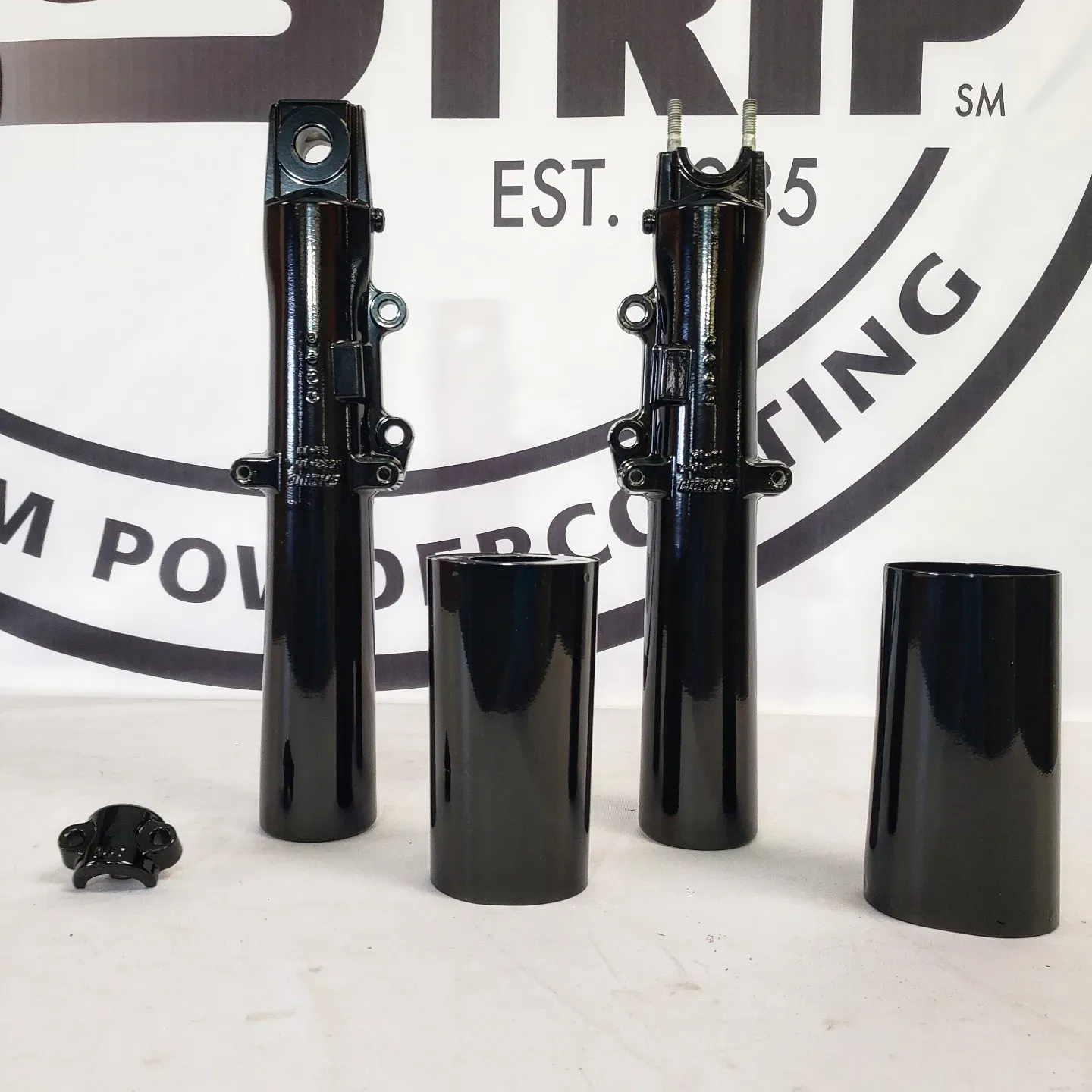 Black cylinders are sitting in front of a sign that says trip