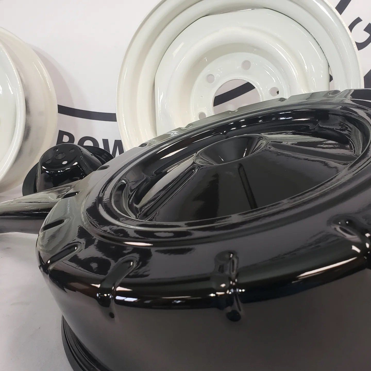 A black pot sits on a table next to a white wheel