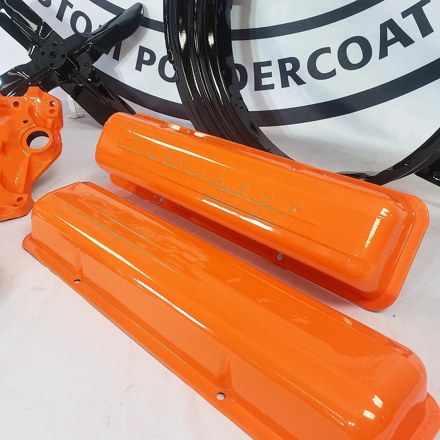 A pair of orange valve covers are sitting on a table