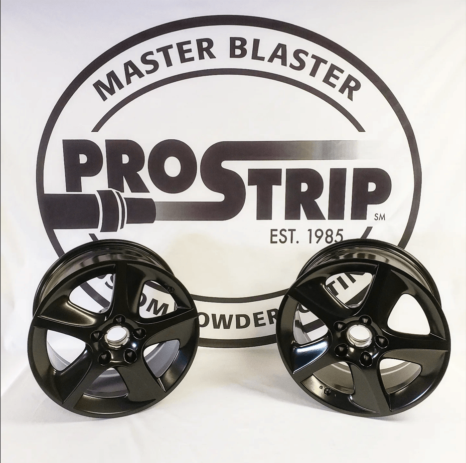 Two black wheels are sitting in front of a master blaster logo