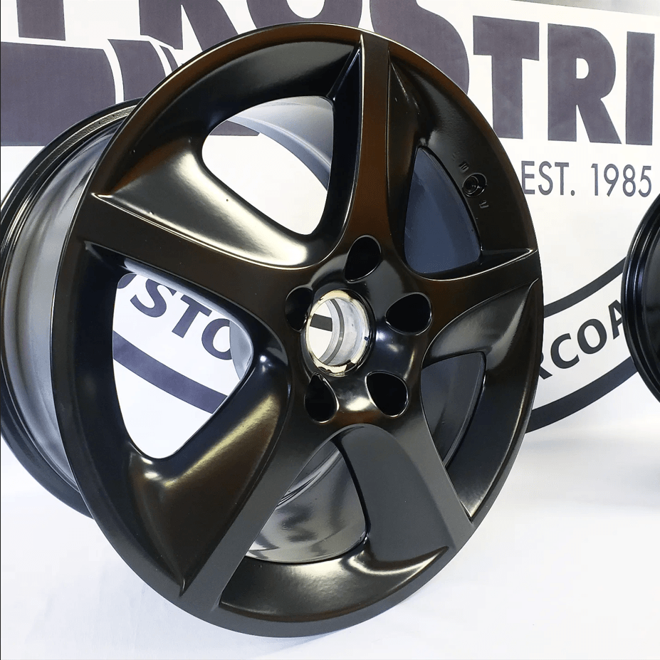 A black wheel sits in front of a sign that says tri