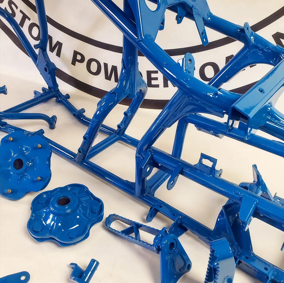 A blue motorcycle frame is sitting on a white table