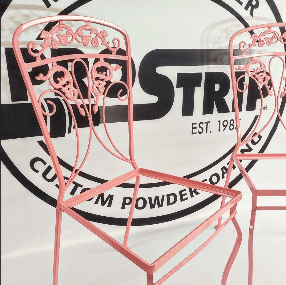 Two pink chairs in front of a sign that says custom powder coating