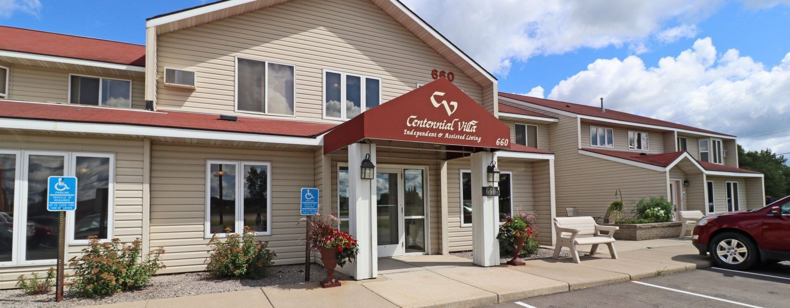 A large building with a red awning and a car parked in front of it.