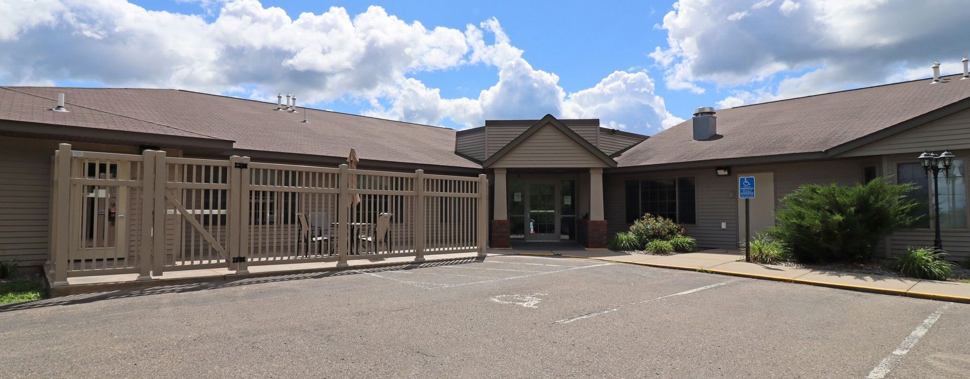 A large house with a parking lot in front of it.