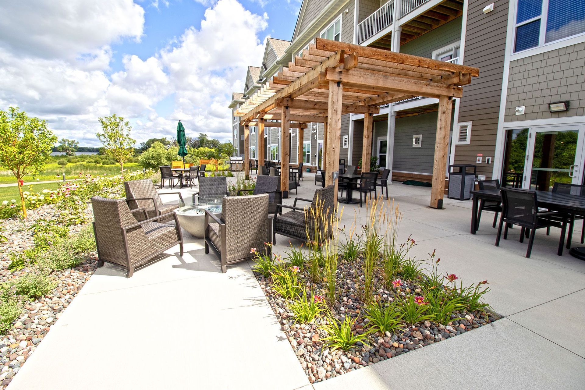 A patio area with tables and chairs under a pergola.