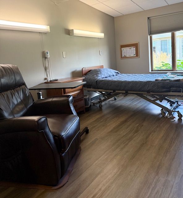 A hospital room with a bed and a clock on the wall.