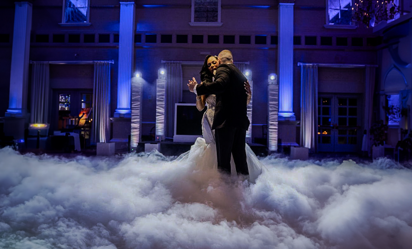 A bride and groom are dancing in the clouds at their wedding reception.
