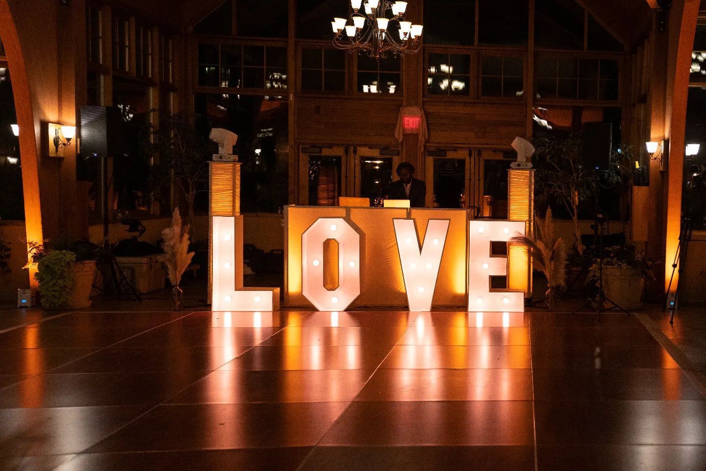 The word love is lit up in large letters on a dance floor.
