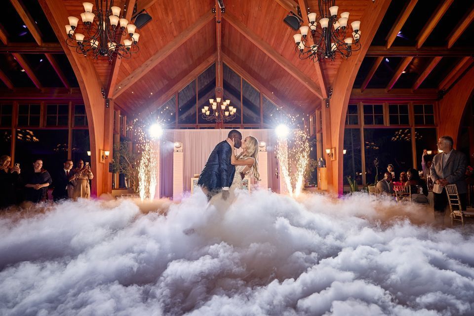 A bride and groom are dancing in the clouds at their wedding reception.
