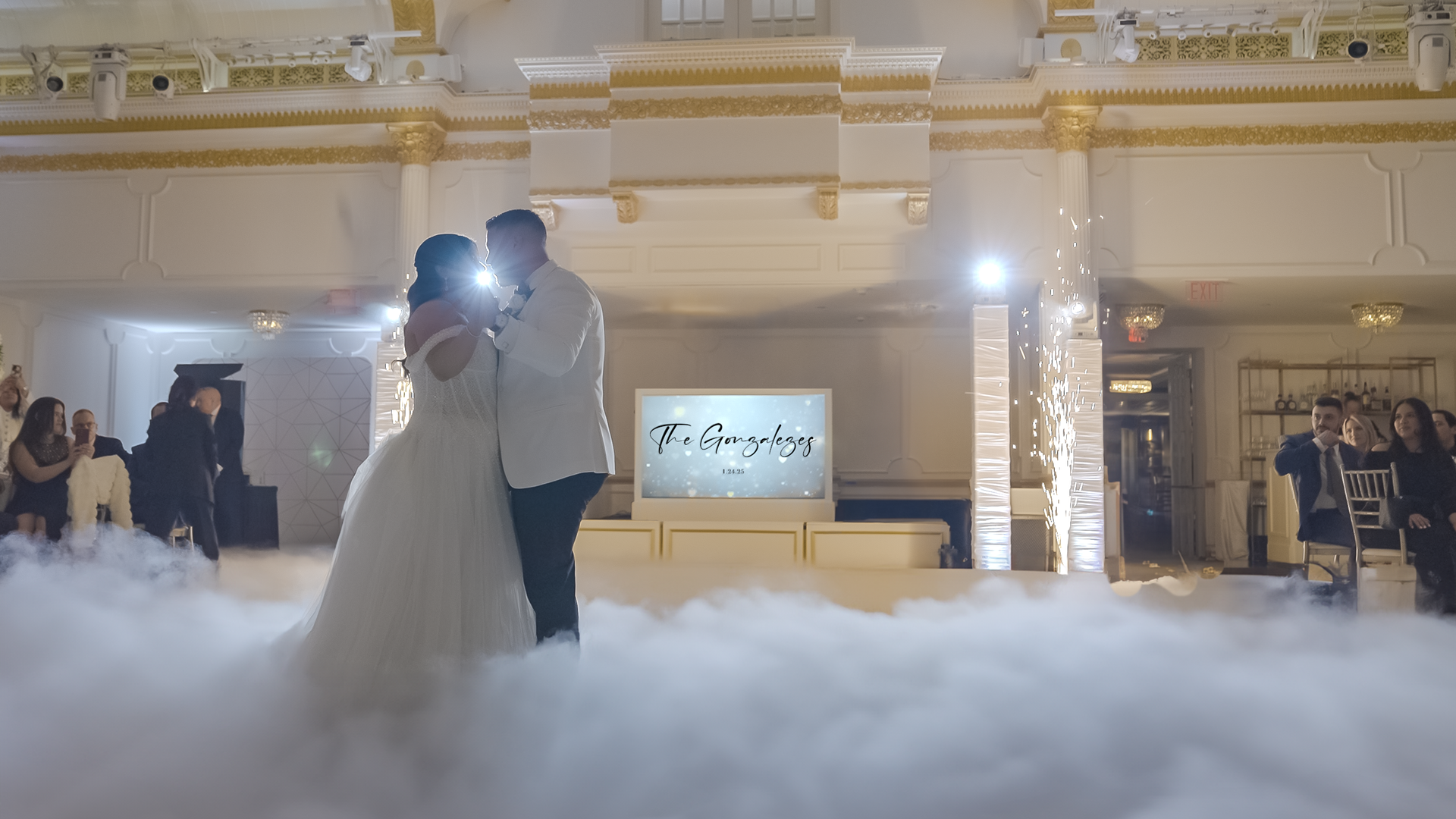 A bride and groom are dancing in the middle of a cloud of smoke at their wedding reception.