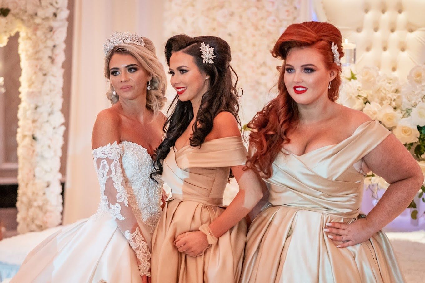 Three women in wedding dresses are posing for a picture.