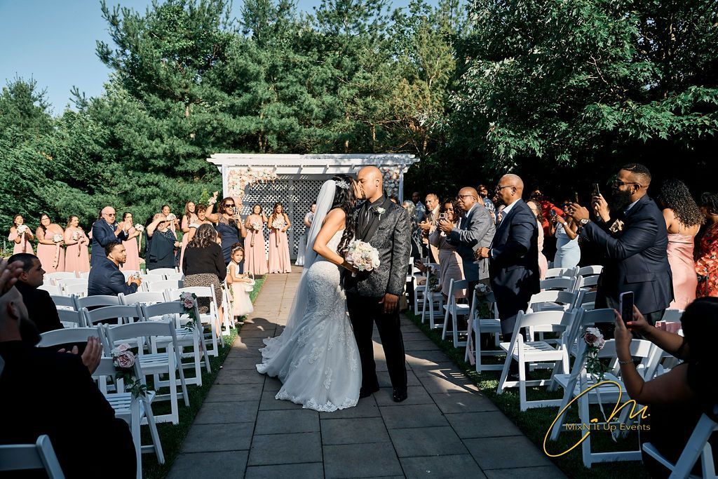 A bride and groom are walking down the aisle at their wedding ceremony.