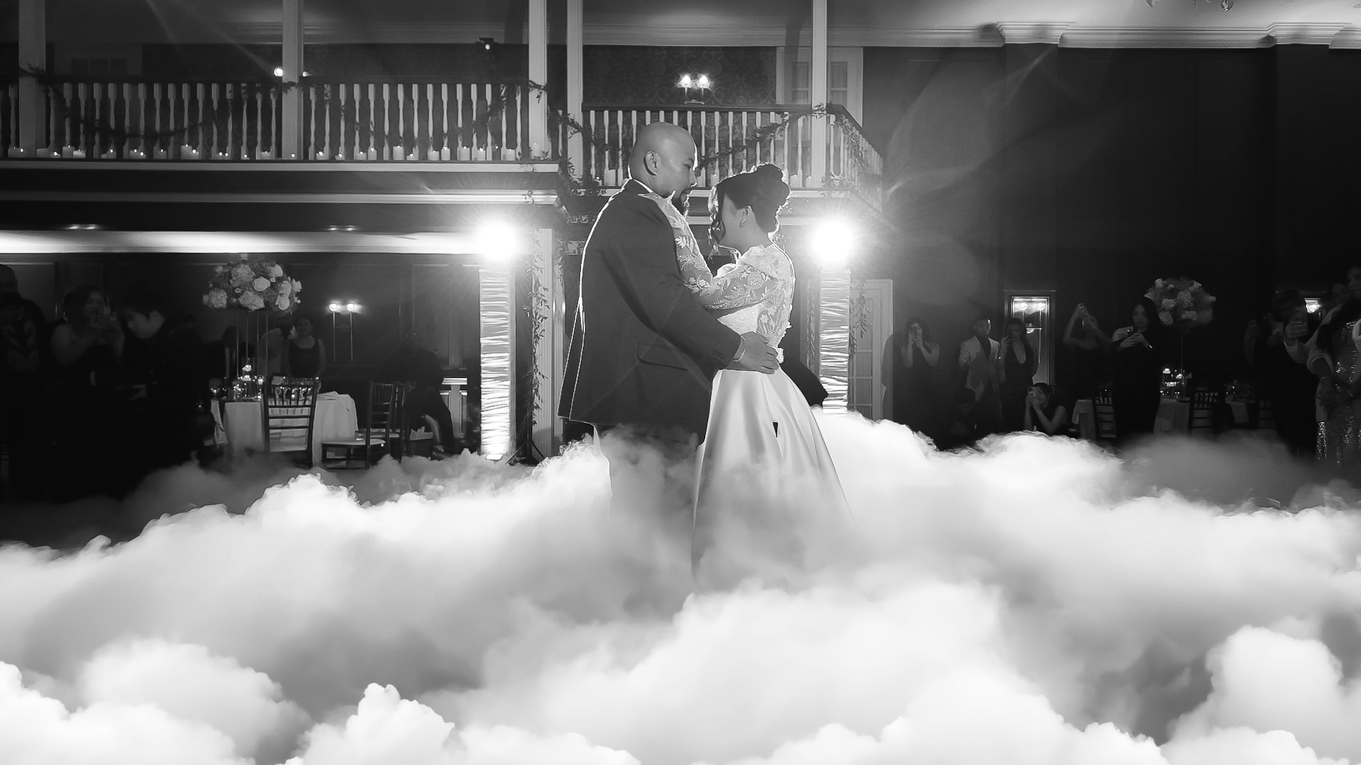 A bride and groom are dancing in the clouds at their wedding reception.
