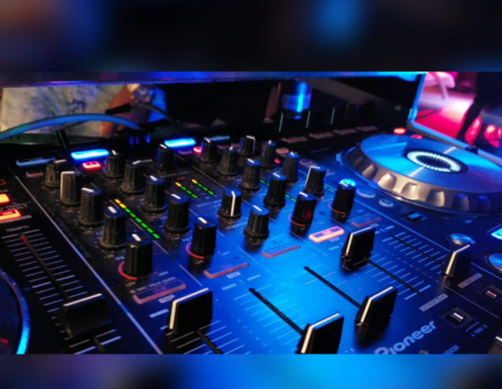 A close up of a pioneer dj mixer in a dark room
