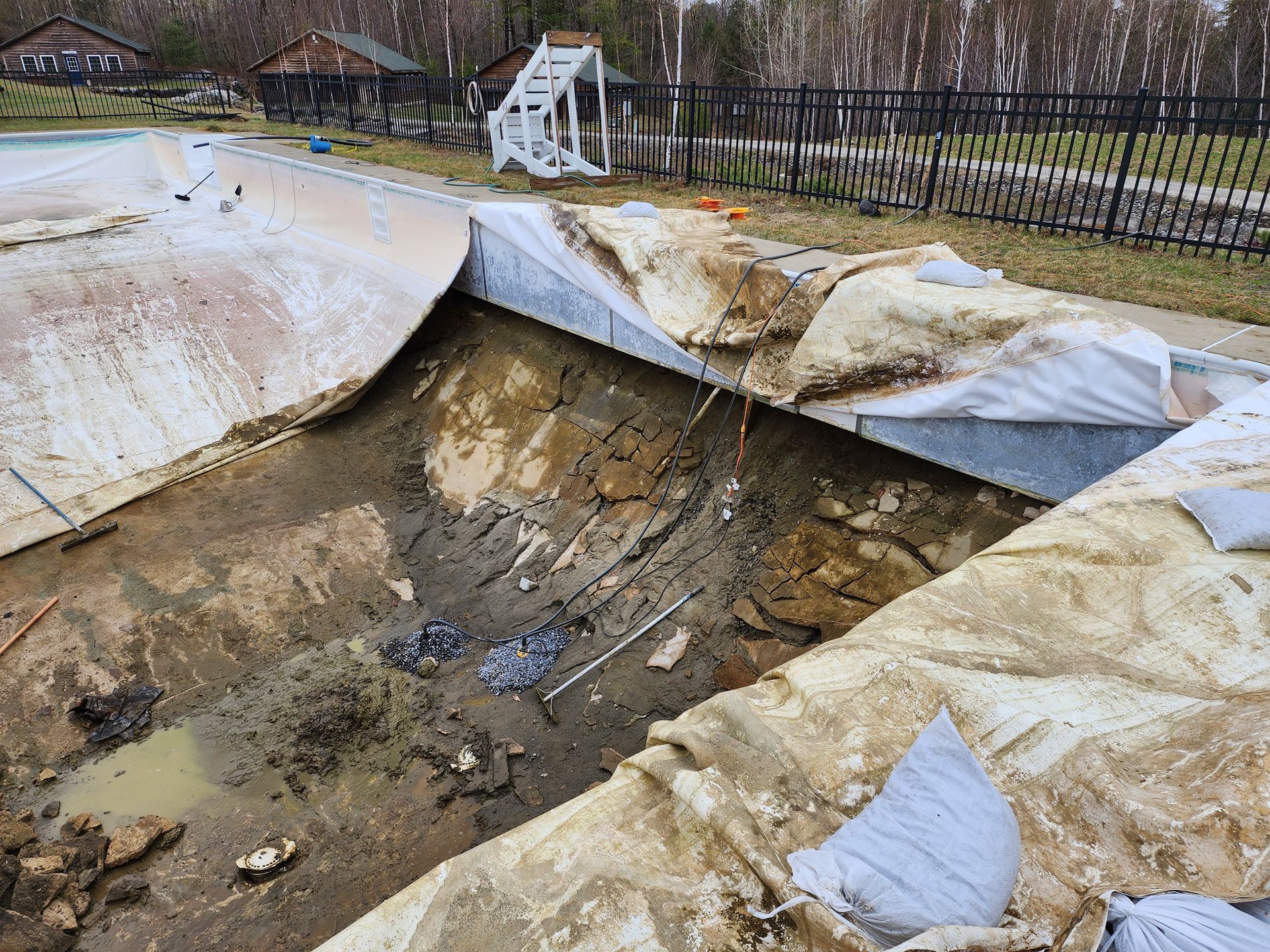 A large hole in the ground next to a swimming pool.