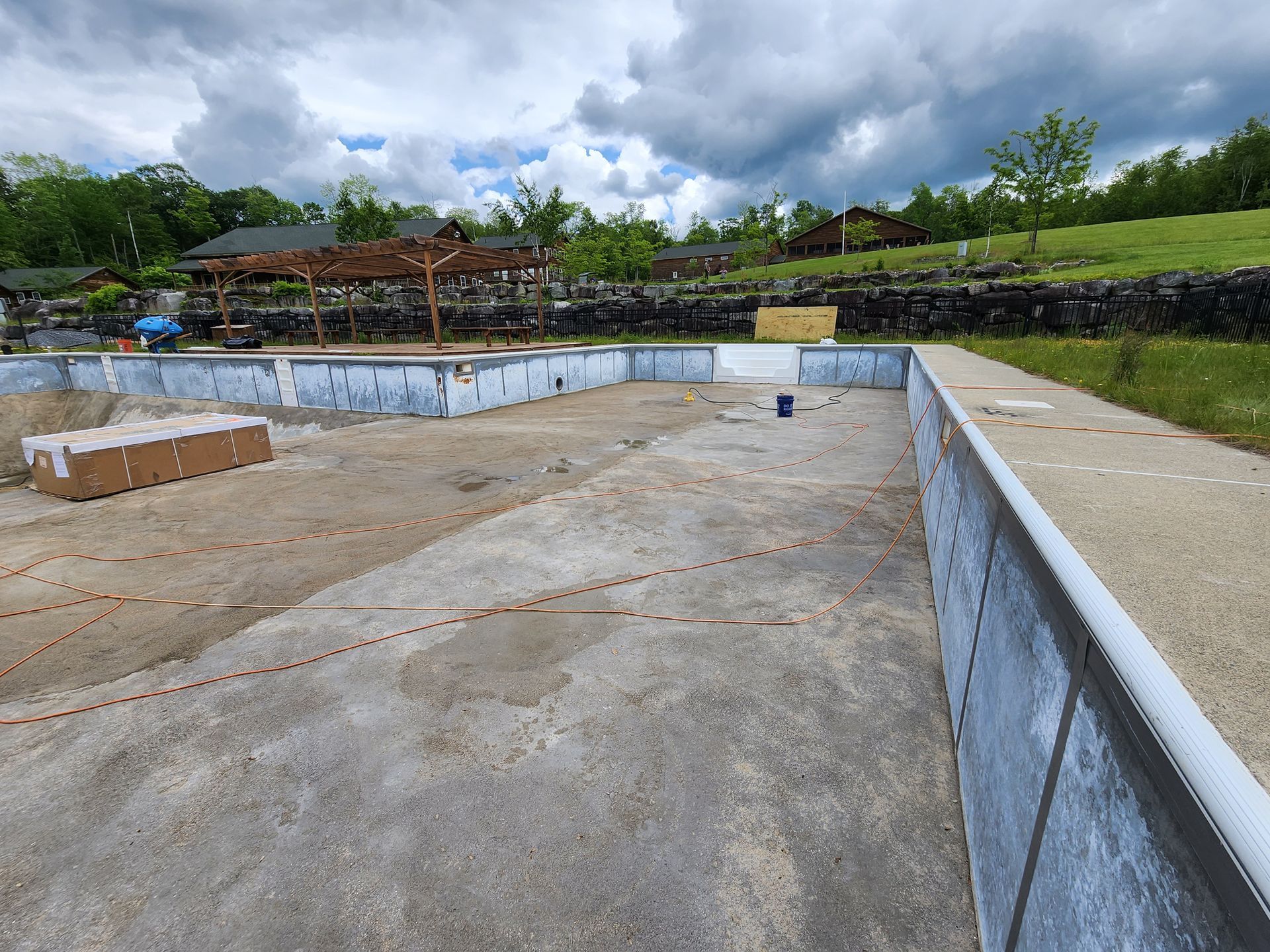 An empty swimming pool is being built in a field