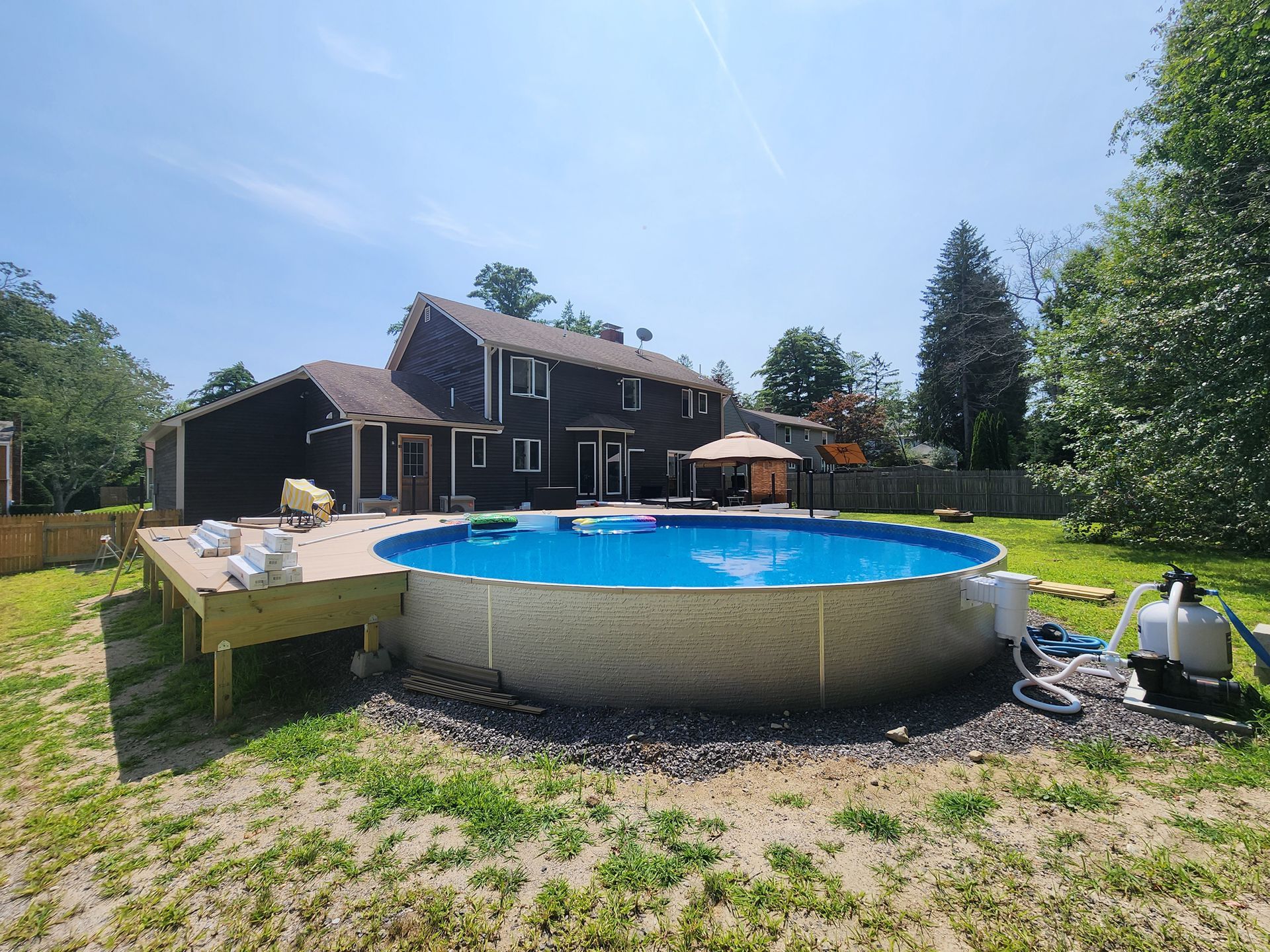 A large swimming pool is in the backyard of a house.