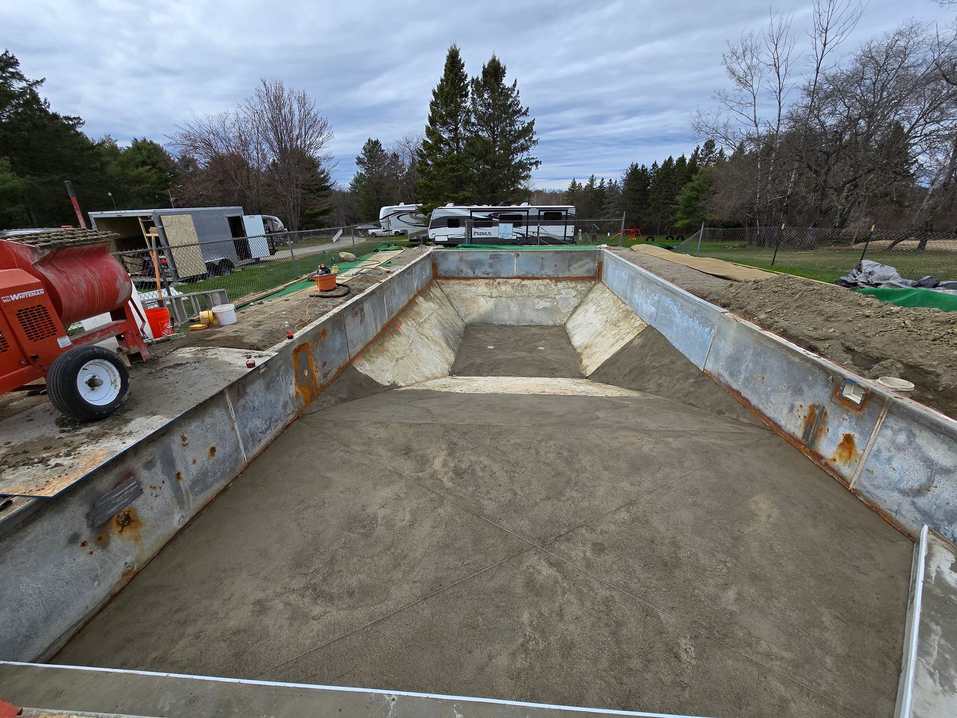 A large concrete container is being filled with concrete