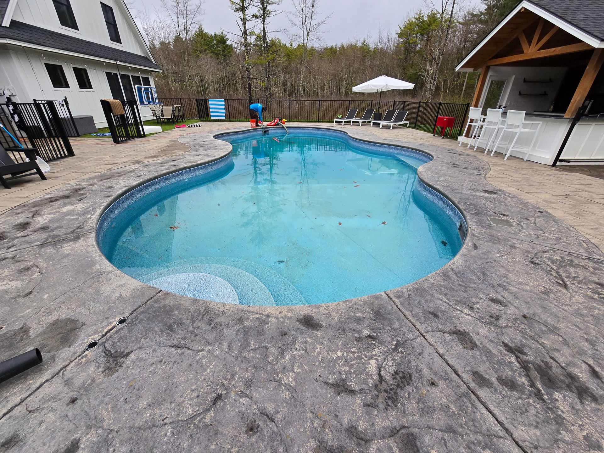 A large swimming pool in the backyard of a house.