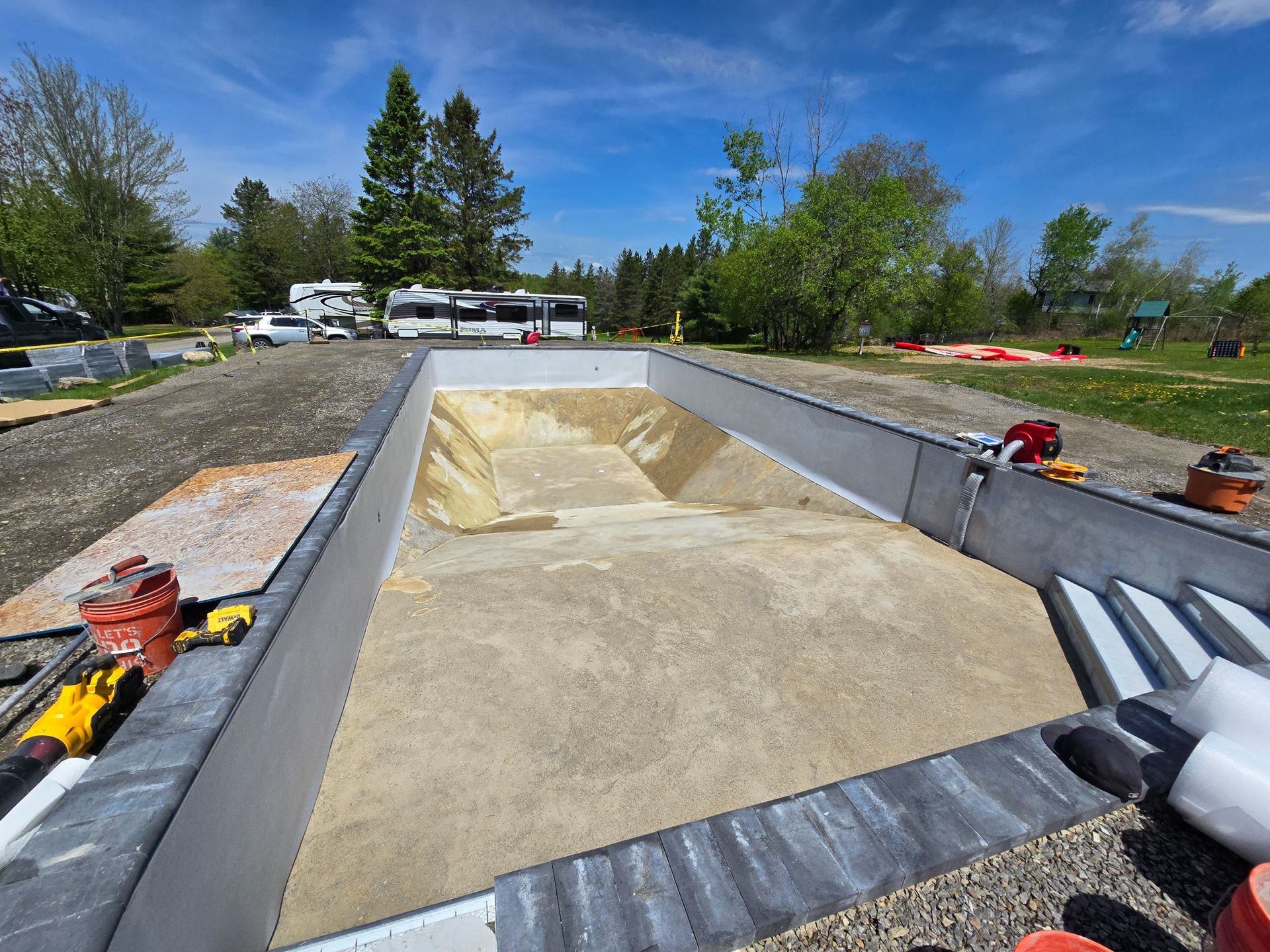 A trailer filled with sand is parked in a parking lot.