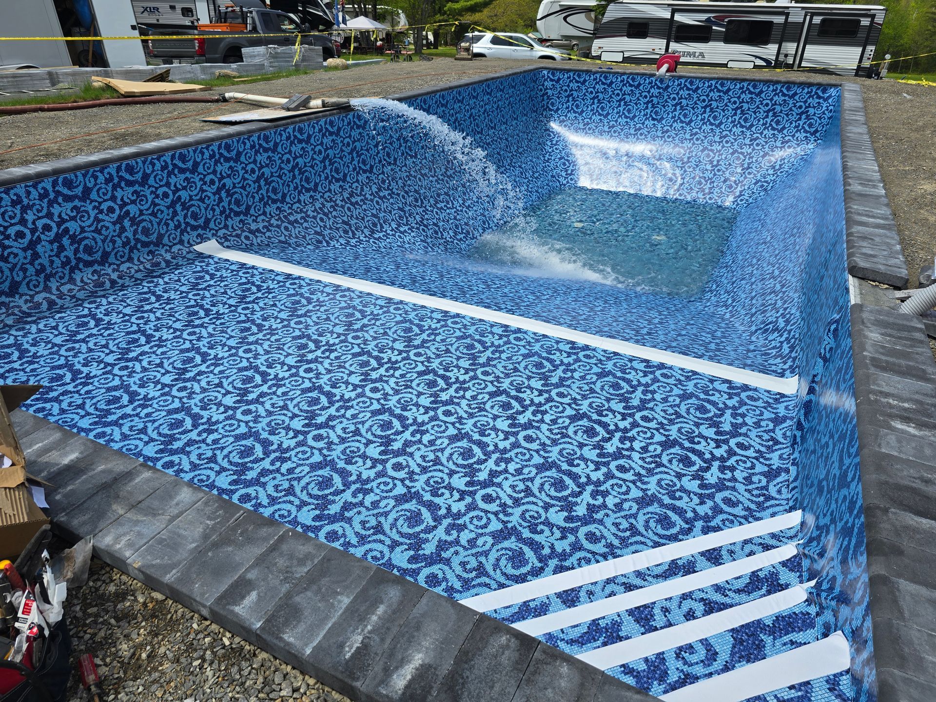 A large swimming pool is being built in a yard.