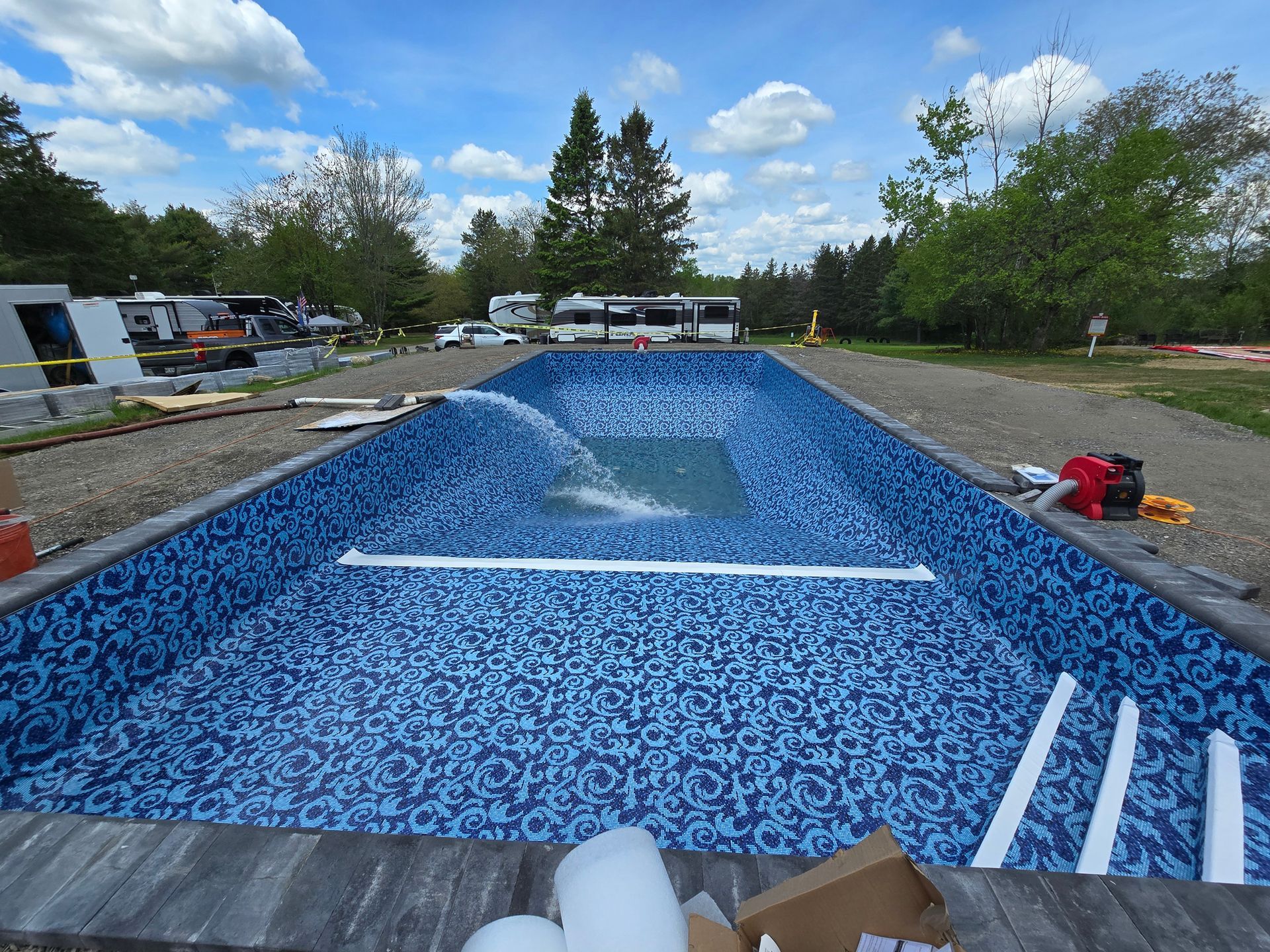 A large swimming pool is being built in a yard.