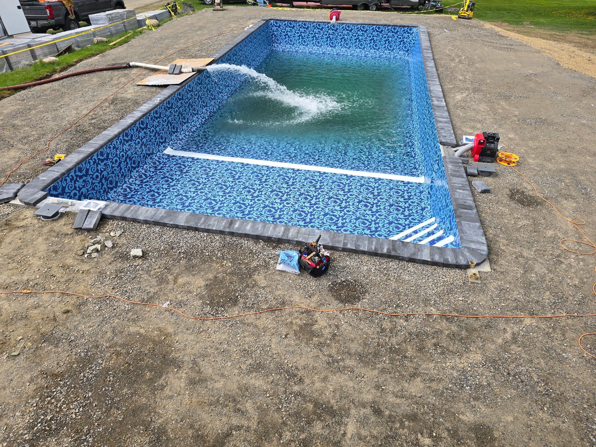 A swimming pool is being built in a dirt lot.