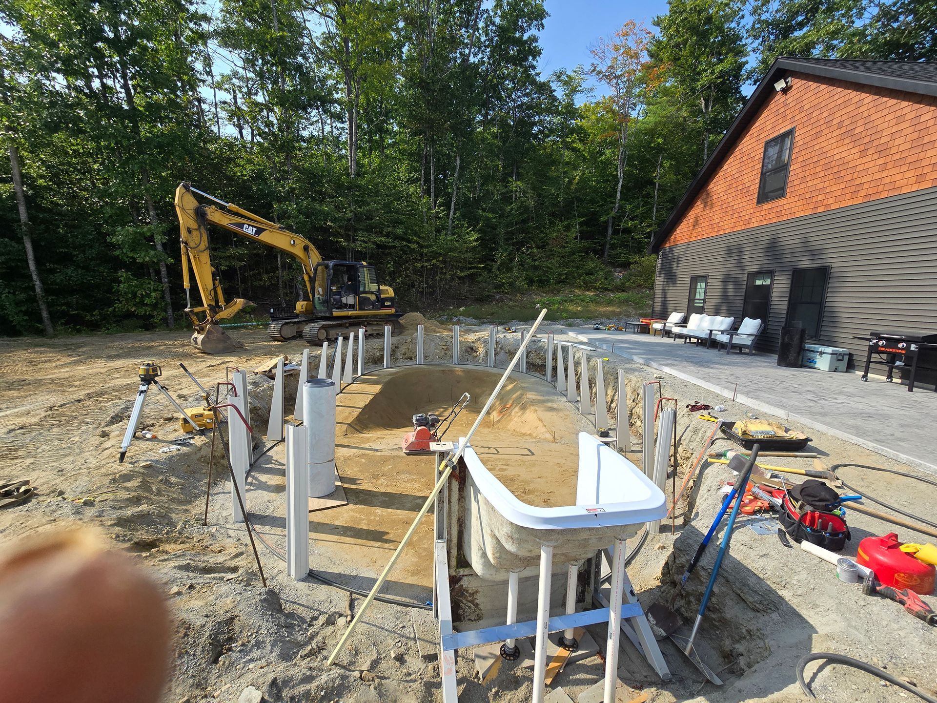 A swimming pool is being built in the backyard of a house.