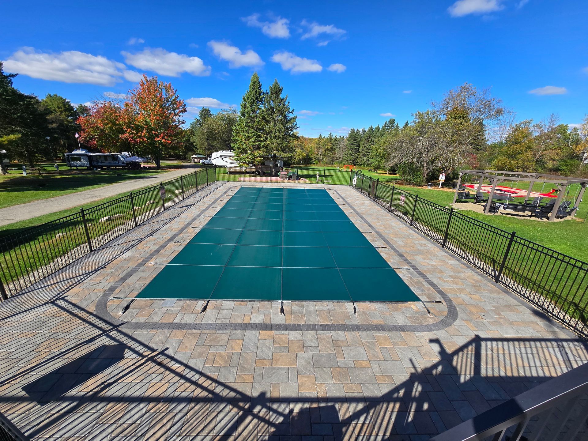 A large swimming pool with a green cover on it