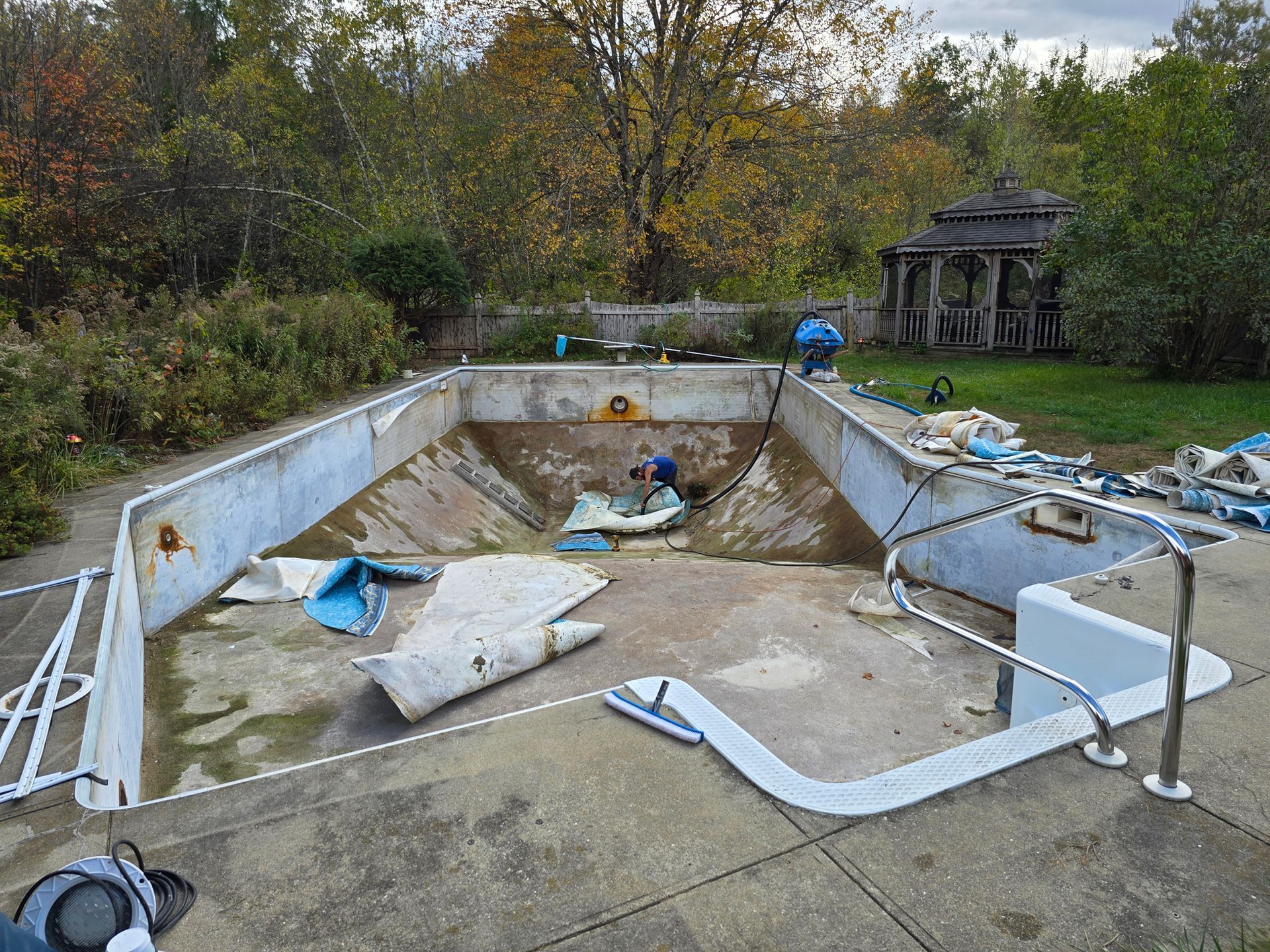 A swimming pool is being remodeled in a backyard.